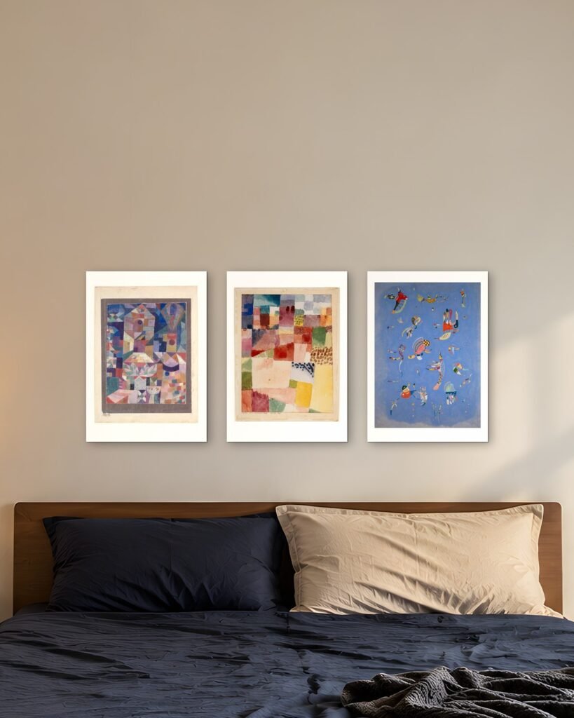 Three prints by Klee and Kandinsky in A3, hung in a row above a bed